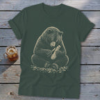 Bear carving wood with a knife on a dark green t-shirt.