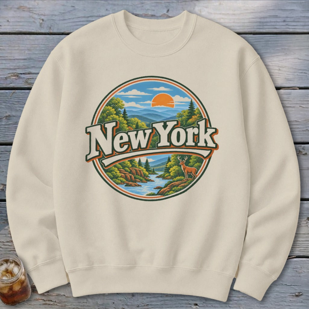 Cream sweatshirt with circular New York landscape graphic featuring deer and mountains.