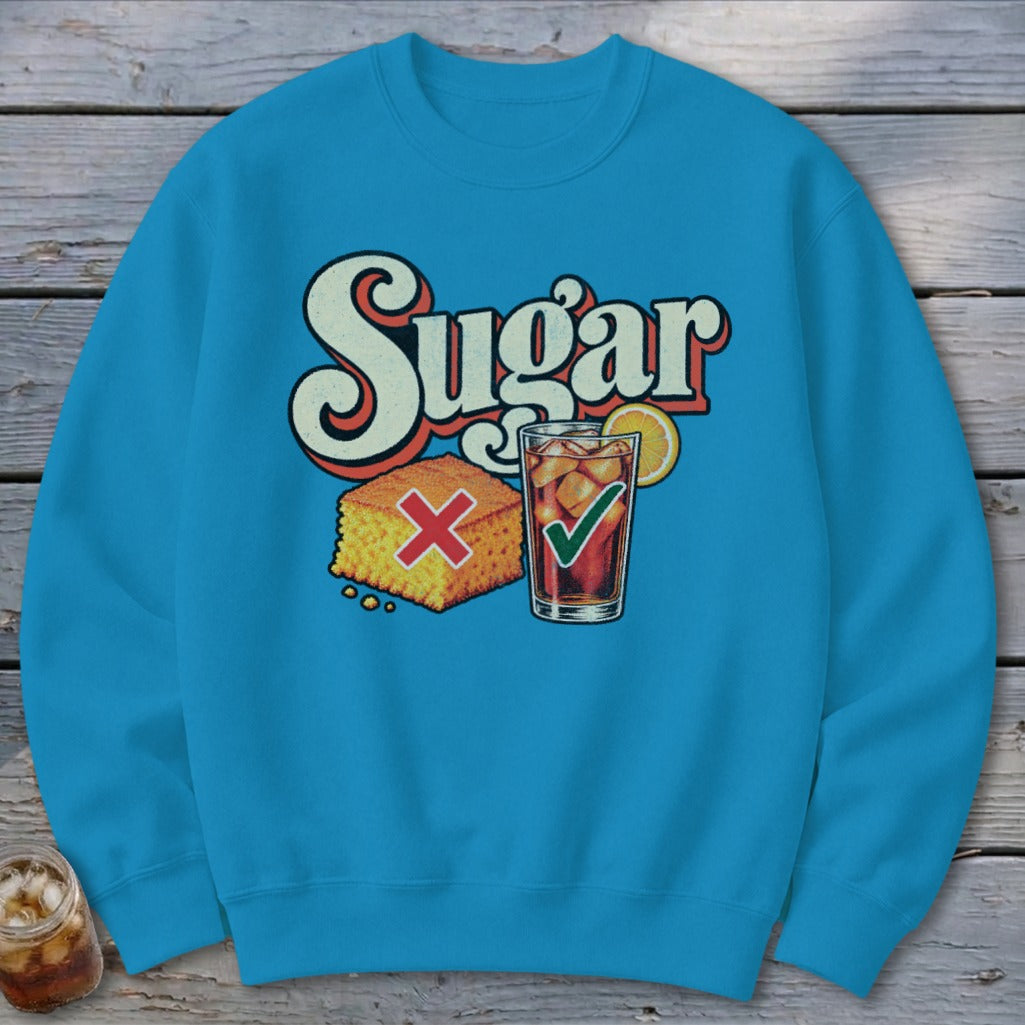 Bright blue crewneck sweatshirt featuring a graphic of cornbread with a red X and iced tea with a green checkmark below retro text reading "Sugar".