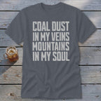Dark grey t-shirt featuring the distressed white text COAL DUST IN MY VEINS MOUNTAINS IN MY SOUL.