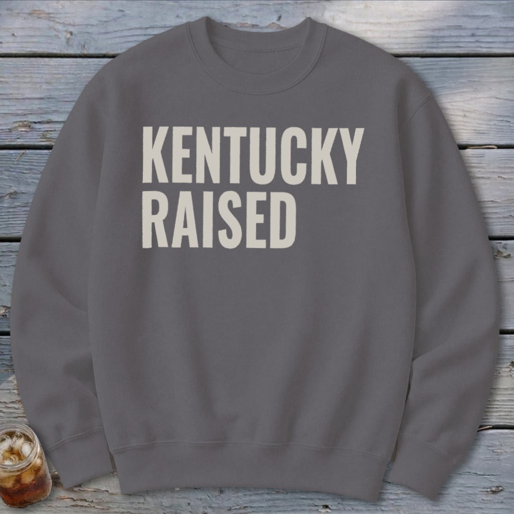 Grey sweatshirt with "KENTUCKY RAISED" text in off-white block letters.