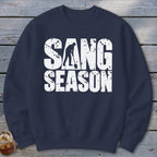 Dark blue crewneck sweatshirt featuring white distressed text reading SANG SEASON with a digger silhouette.