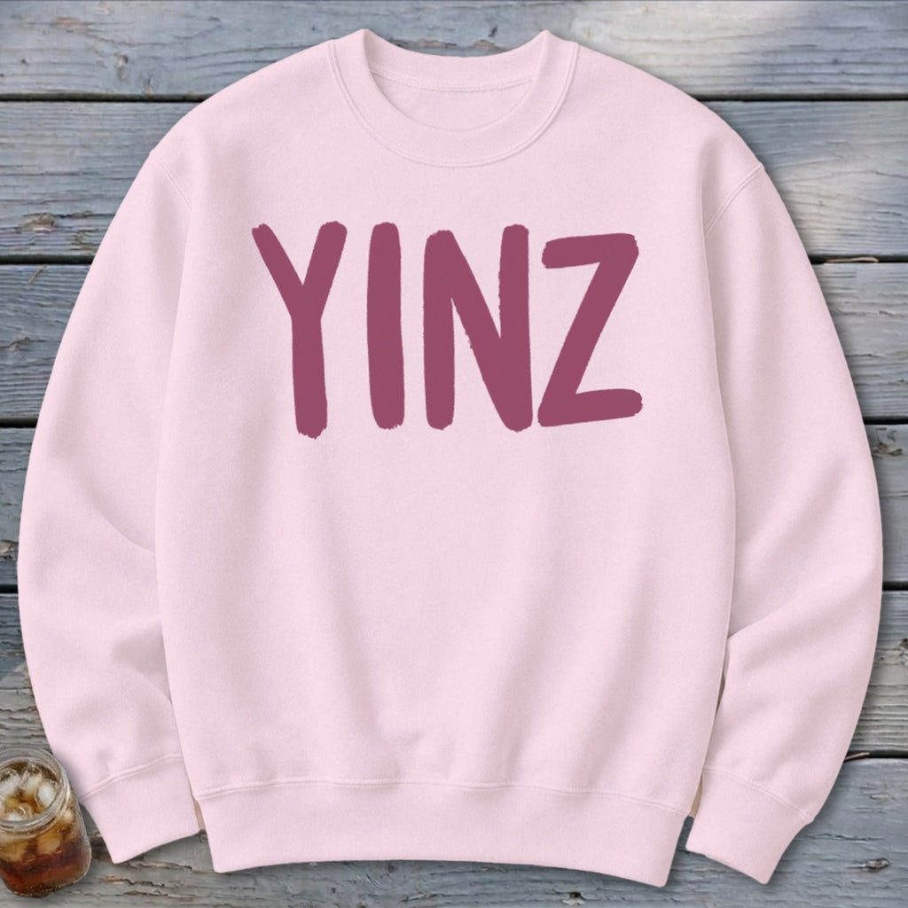 Light pink crewneck sweatshirt with large purple "YINZ" graphic.