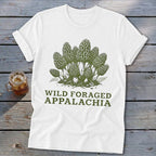 White t-shirt with green graphic of morel mushrooms and text "WILD FORAGED APPALACHIA".
