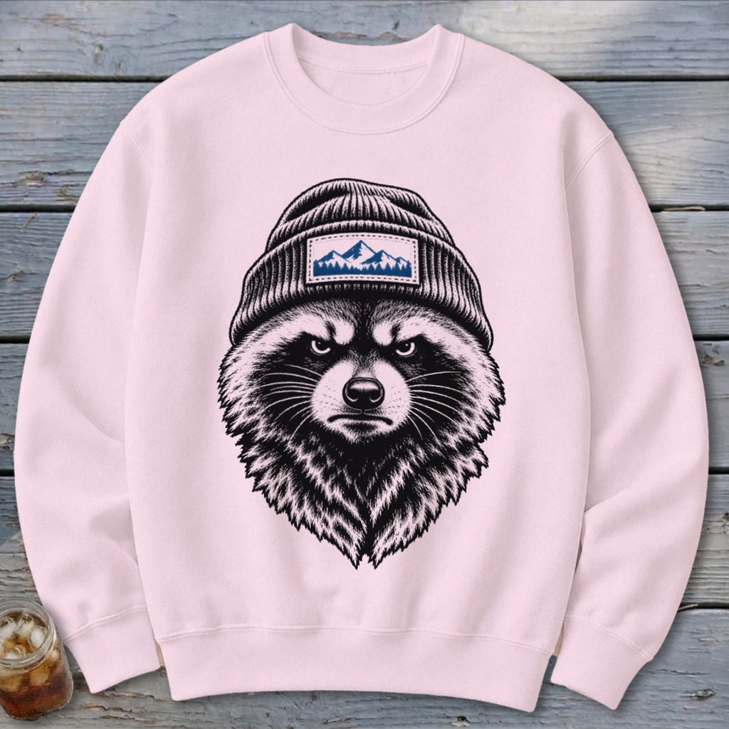 Pink crewneck sweatshirt with a graphic of an angry raccoon wearing a beanie with mountains.