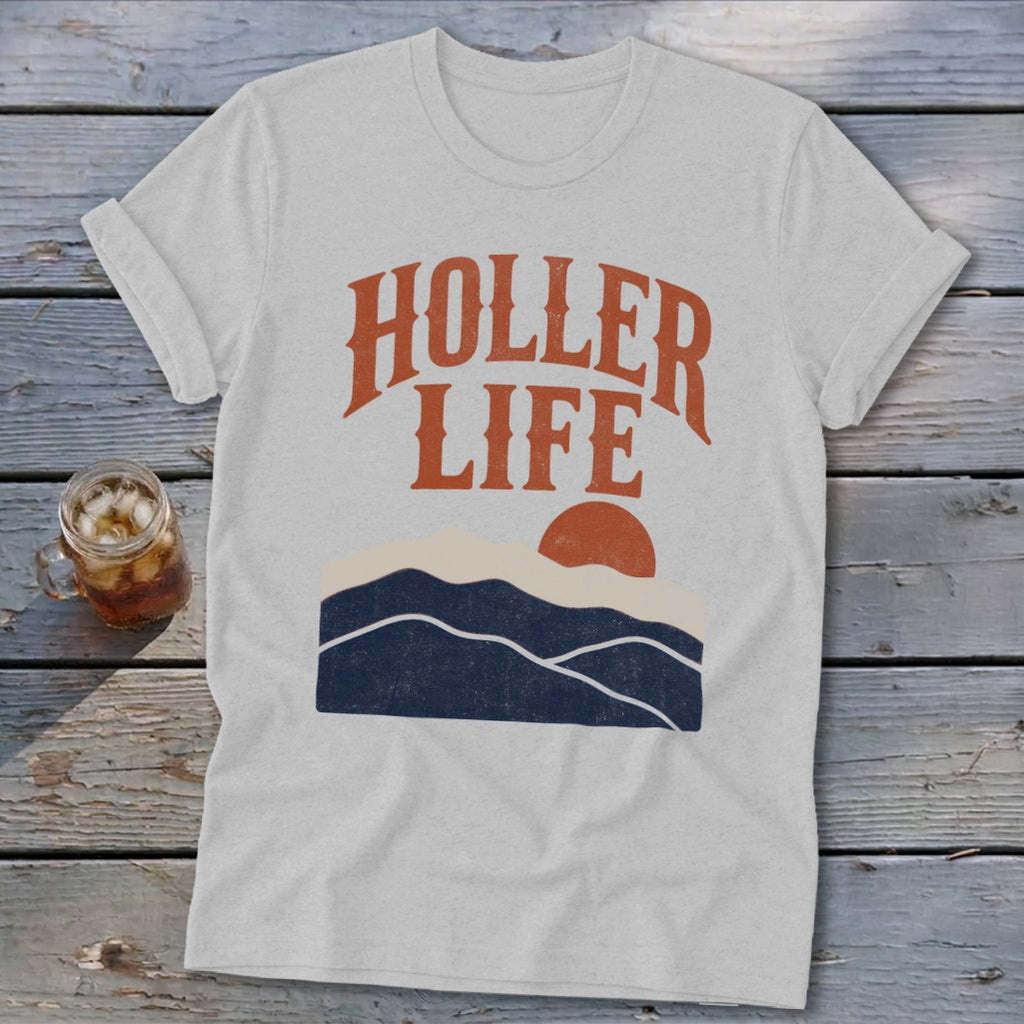 A light gray t-shirt with the orange text "HOLLER LIFE" and a mountain sunset graphic.