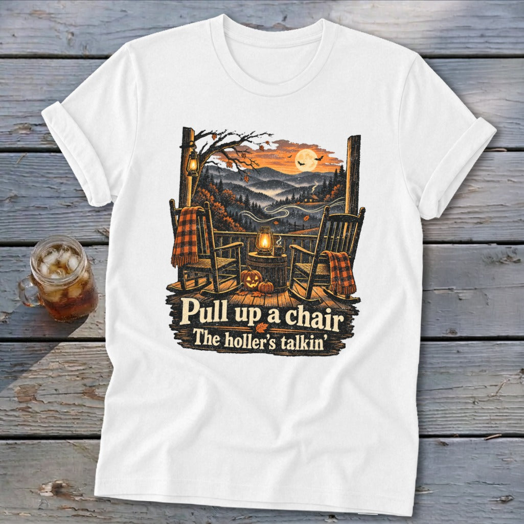 White t-shirt with rocking chairs, pumpkins, and fall landscape, reading "Pull up a chair The holler's talkin'".