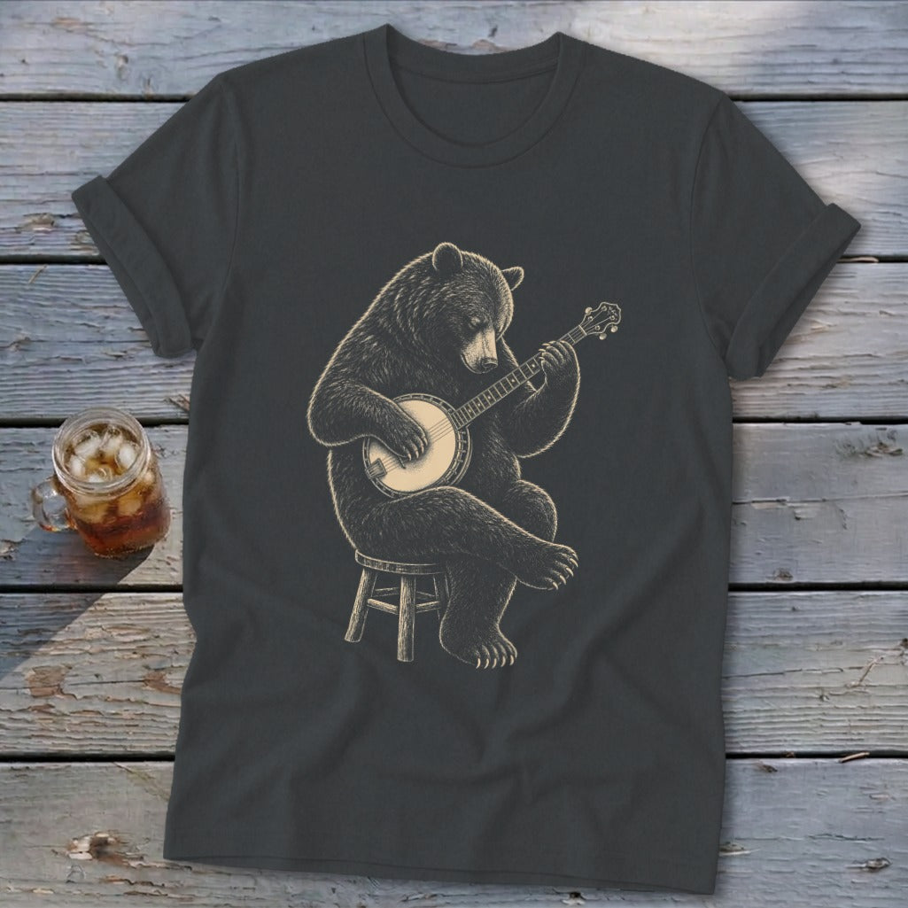 Bear playing banjo on a stool, graphic design on a dark t-shirt.