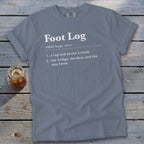 Blue-grey t-shirt featuring dictionary-style text defining Foot Log laid across a wooden background.