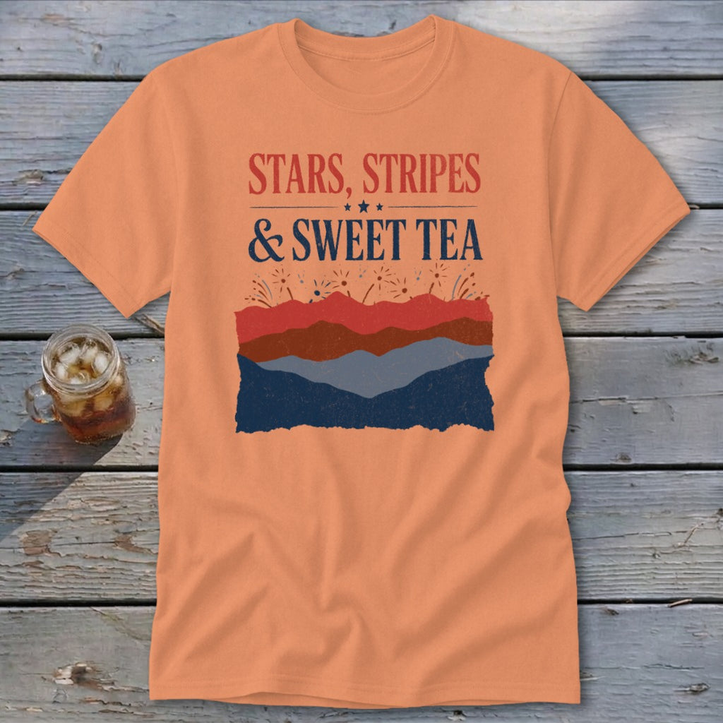 Peach t-shirt with distressed text reading Stars, Stripes & Sweet Tea above layered red and blue landscape graphics.