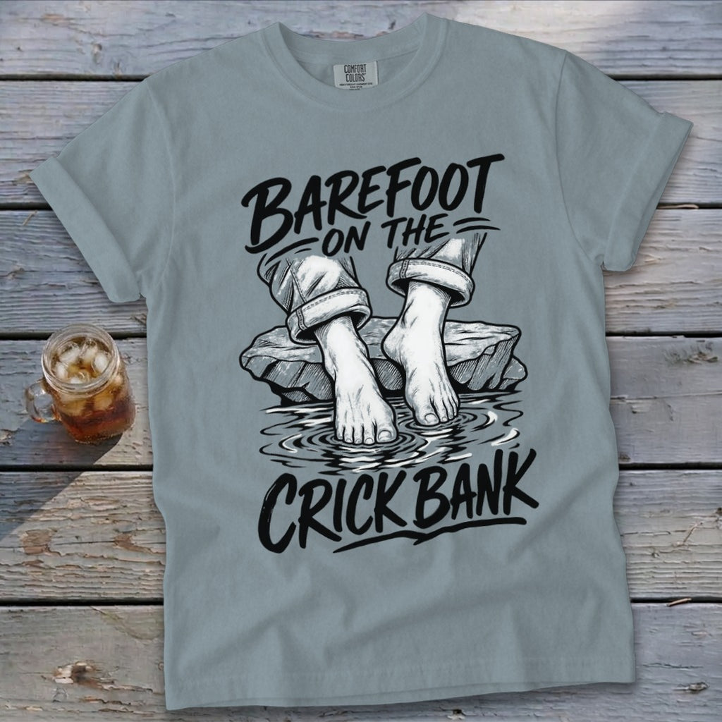 Light blue t-shirt with "BAREFOOT ON THE CRICK BANK" text and graphic.
