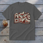 Charcoal t-shirt featuring a stylized graphic of mountains, trees, and cabins resembling a quilt on a wooden surface.