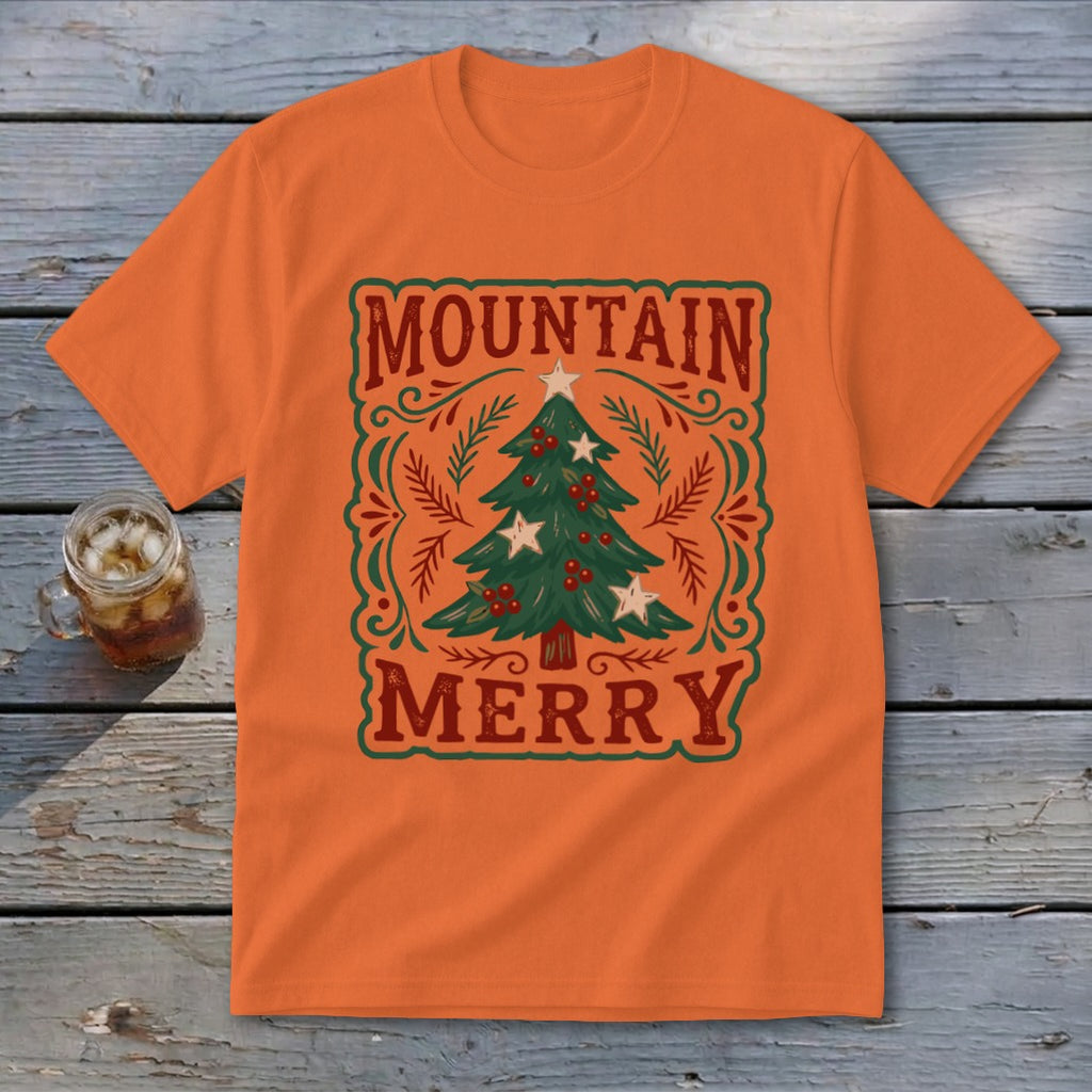 An orange crew neck t-shirt featuring a green Christmas tree graphic and the text Mountain Merry.