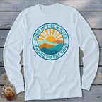 A white long-sleeved t-shirt features a circular graphic with mountains, a rising sun, and the text Born in the Holler, Raised on the Ridge.