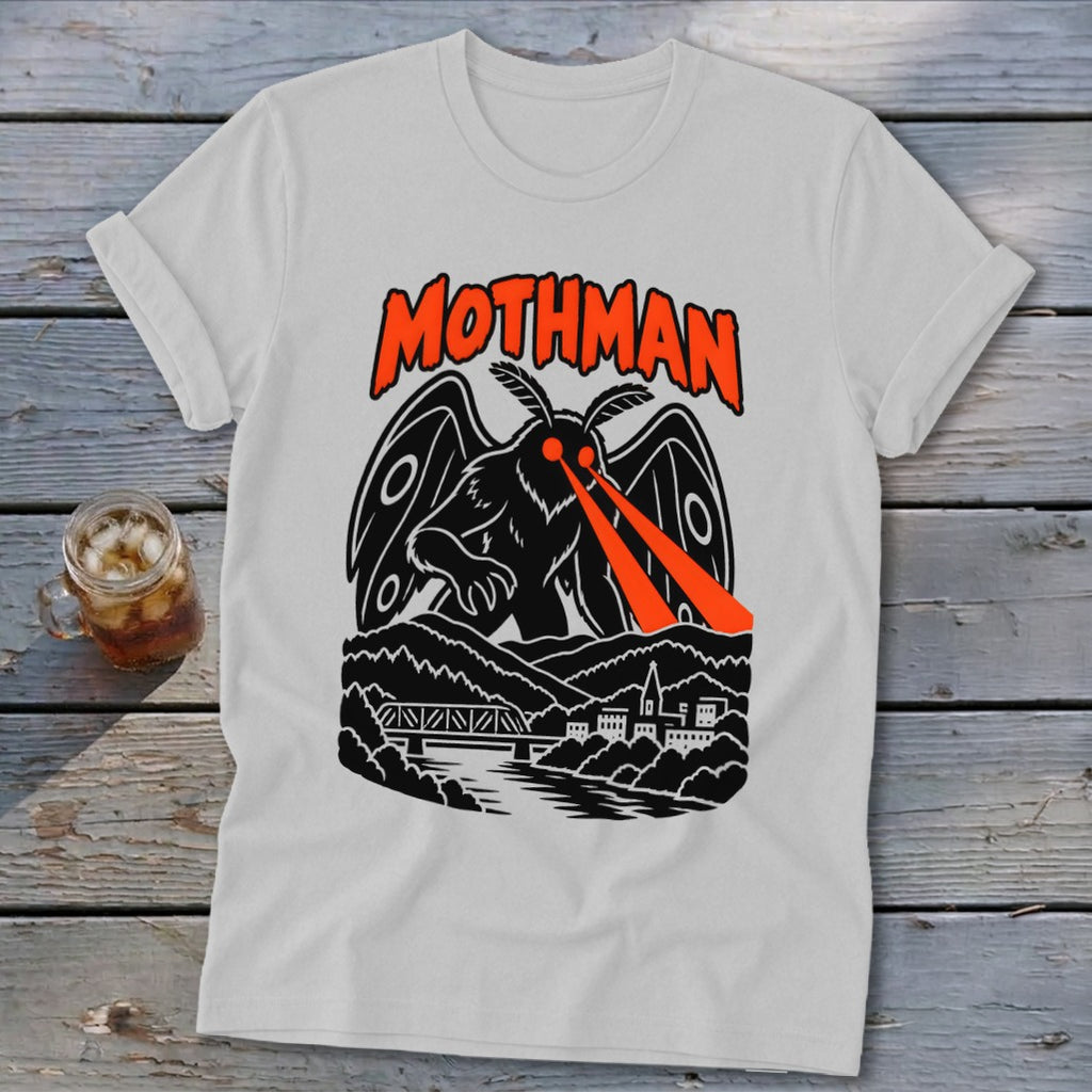 Mothman graphic on a t-shirt with red laser eyes, mountains, bridge, and town.