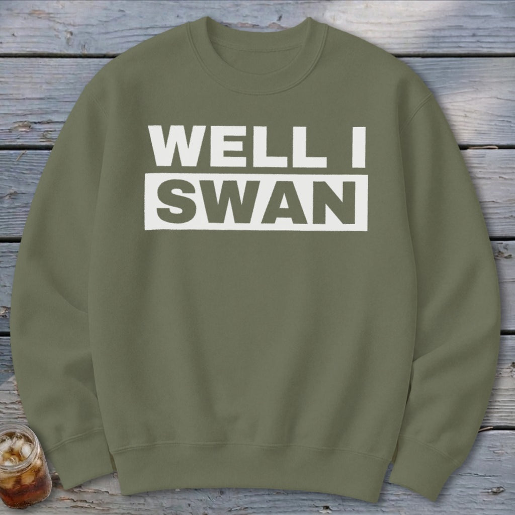 Olive green crewneck sweatshirt featuring white block lettering that reads WELL I SWAN.