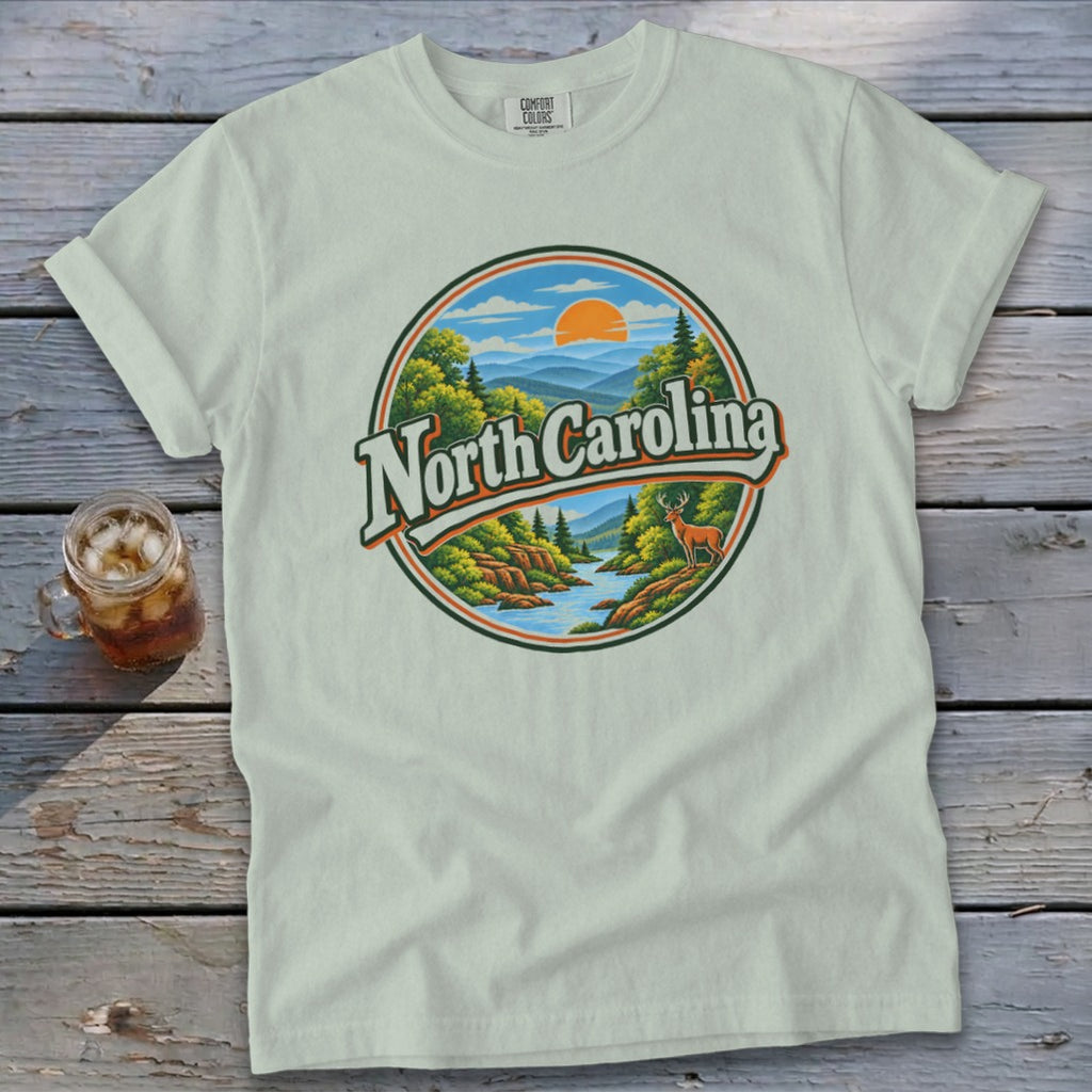Light green t-shirt with a circular graphic of North Carolina mountains, river, and deer.