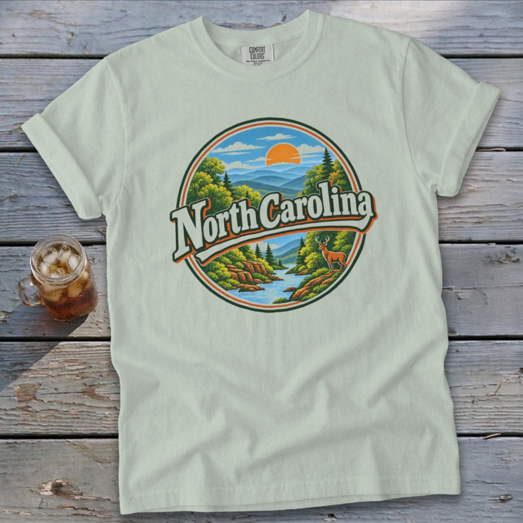 Light green t-shirt with a circular graphic of North Carolina mountains, river, and deer.