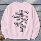 Light pink crewneck sweatshirt with a black graphic of a wooden post featuring directional distance signs.