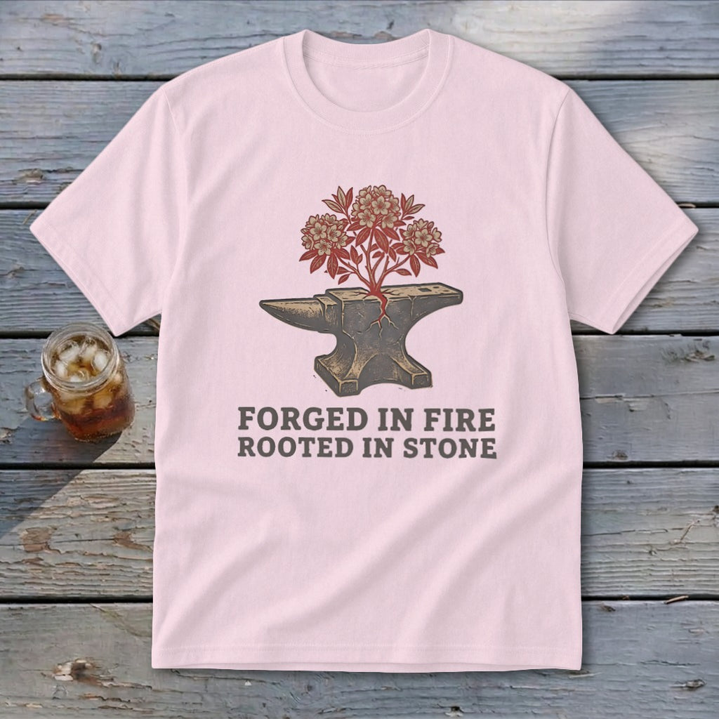 Pink t-shirt with graphic of anvil with plant and text "Forged in Fire Rooted in Stone".