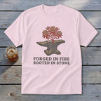 Pink t-shirt with graphic of anvil with plant and text "Forged in Fire Rooted in Stone".