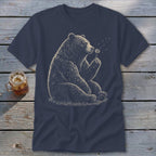 Bear sitting and blowing on a dandelion on a navy t-shirt.