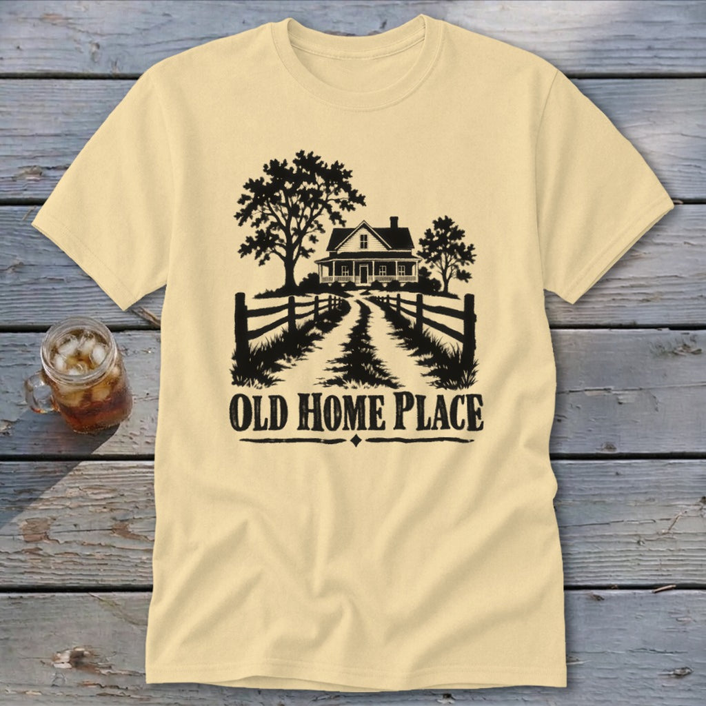 Light yellow t-shirt with black graphic of a farmhouse, trees, fence, and "OLD HOME PLACE" text.