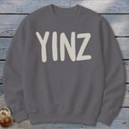 Gray sweatshirt with "YINZ" written in tan block letters.