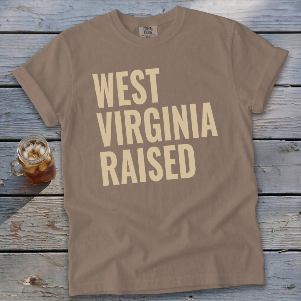 Brown t-shirt with "West Virginia Raised" printed in beige text.