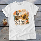 White t-shirt with graphic of sunflower, water tower, and "Small Town Fall Vibes".