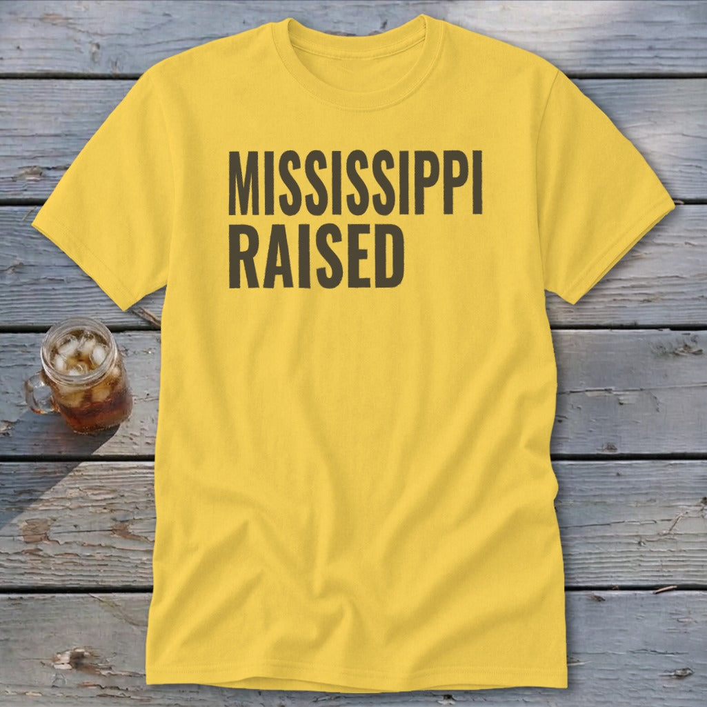 Yellow t-shirt with black text reading "MISSISSIPPI RAISED".