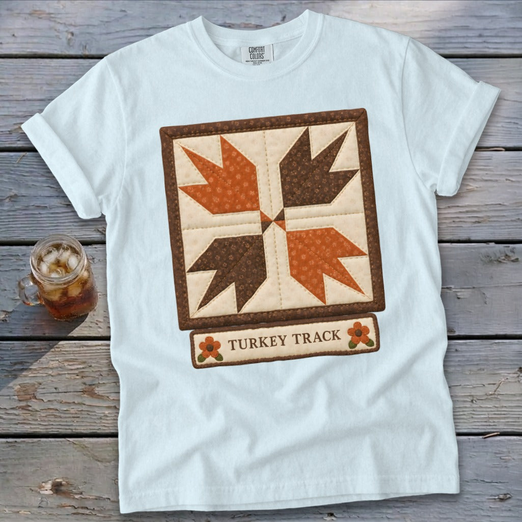 White t-shirt with a quilt block design and "Turkey Track" text.
