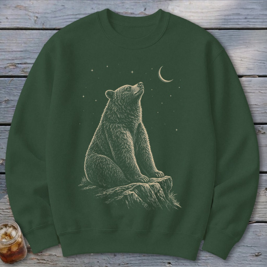 Green sweatshirt with a stylized illustration of a bear sitting on a rock under a starry night sky.