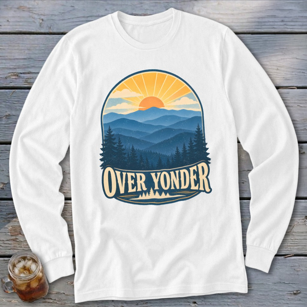 A white long-sleeved t-shirt featuring a retro graphic of mountains, pine trees, a setting sun, and the text Over Yonder.