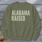 Olive green sweatshirt with "ALABAMA RAISED" text in light beige.