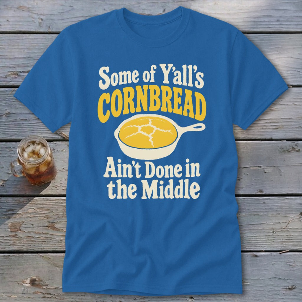 Blue t-shirt featuring a graphic of cornbread in a skillet and text reading Some of Yall's Cornbread Ain't Done in the Middle