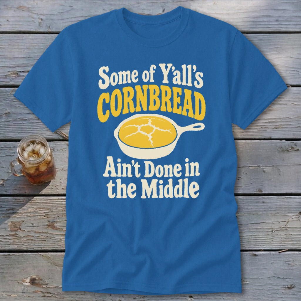 Blue t-shirt featuring a graphic of cornbread in a skillet and text reading Some of Yall's Cornbread Ain't Done in the Middle