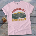 Pink Comfort Colors t-shirt with "Mountain Raised Holler Made" mountain graphic.