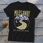 Black t-shirt with "MILES AWAY" above a circular mountain road design and "BUT MOUNTAIN BOUND" text.
