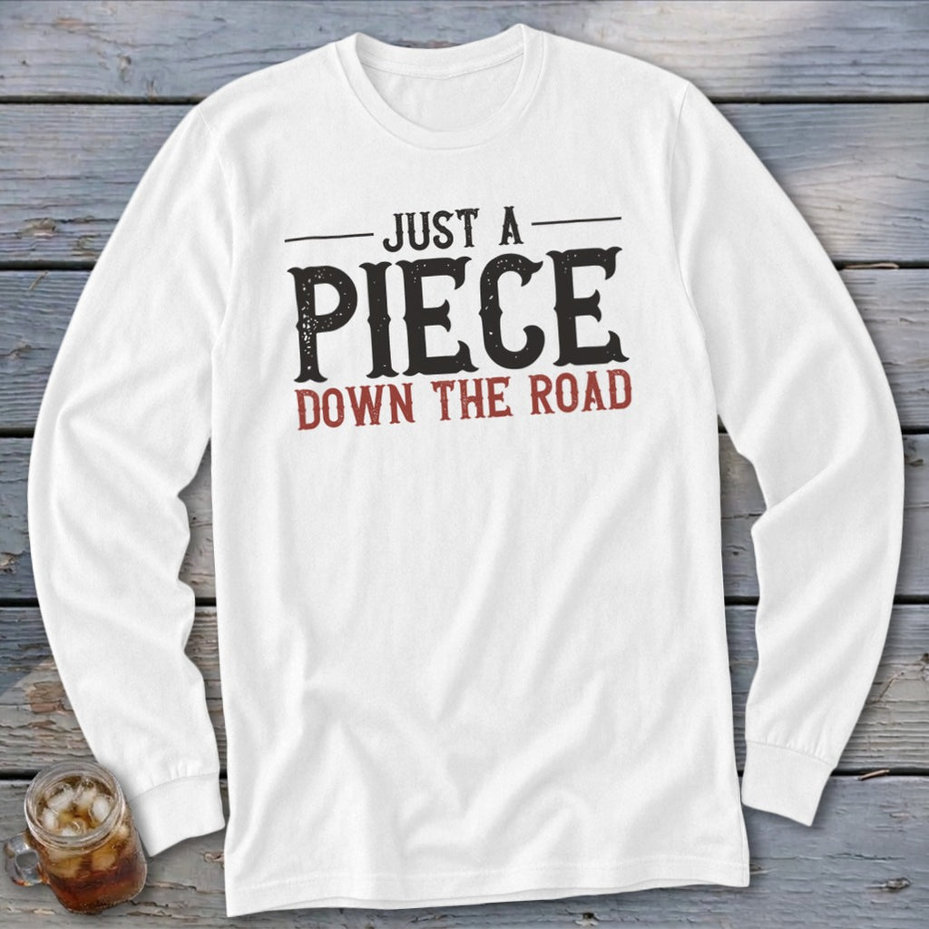 White long sleeve shirt with "JUST A PIECE DOWN THE ROAD" graphic.