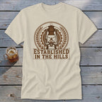 Cream t-shirt with a brown graphic of a lantern and text "ESTABLISHED IN THE HILLS".