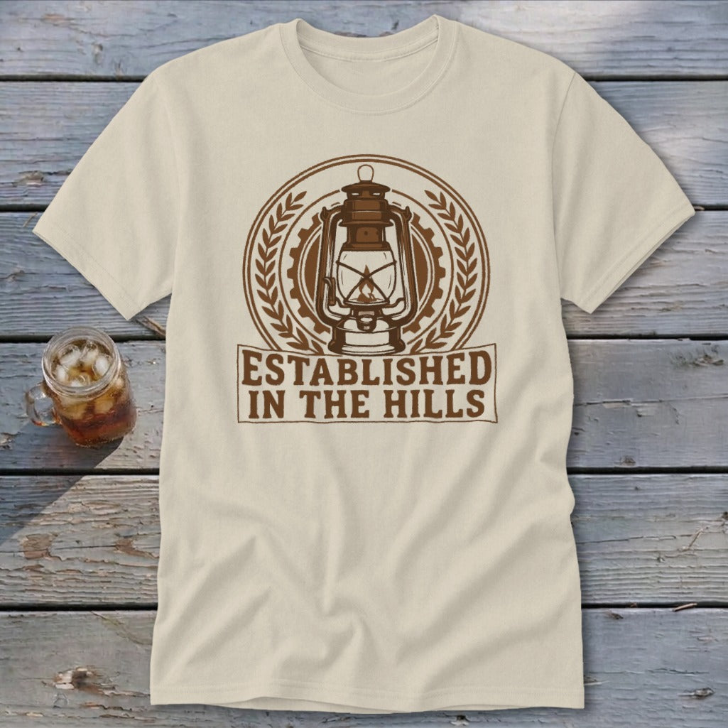 Cream t-shirt with a brown graphic of a lantern and text "ESTABLISHED IN THE HILLS".