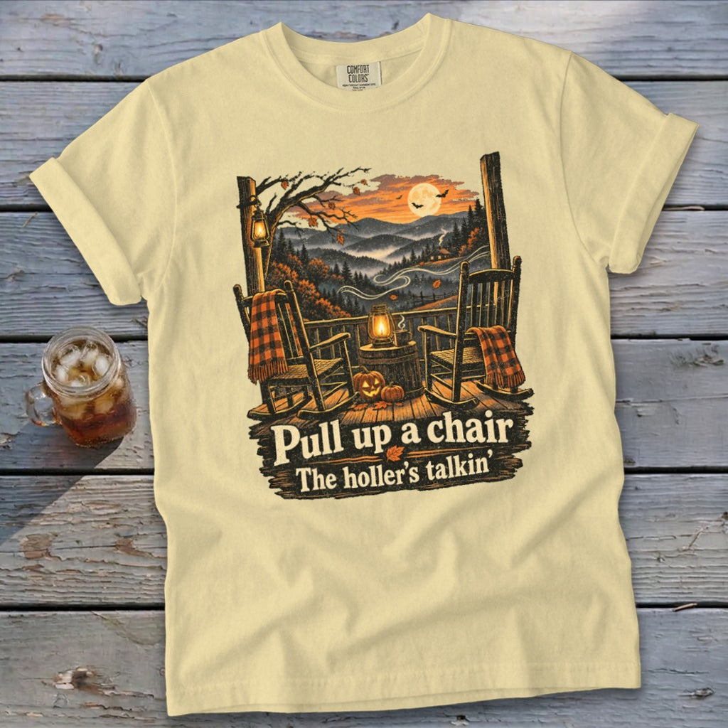 Cream t-shirt with a porch scene, rocking chairs, pumpkins, and text "Pull up a chair, The holler's talkin'".
