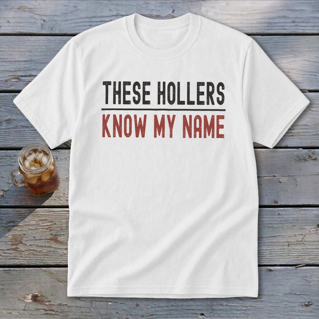White t-shirt with "THESE HOLLERS KNOW MY NAME" printed in black and red text.