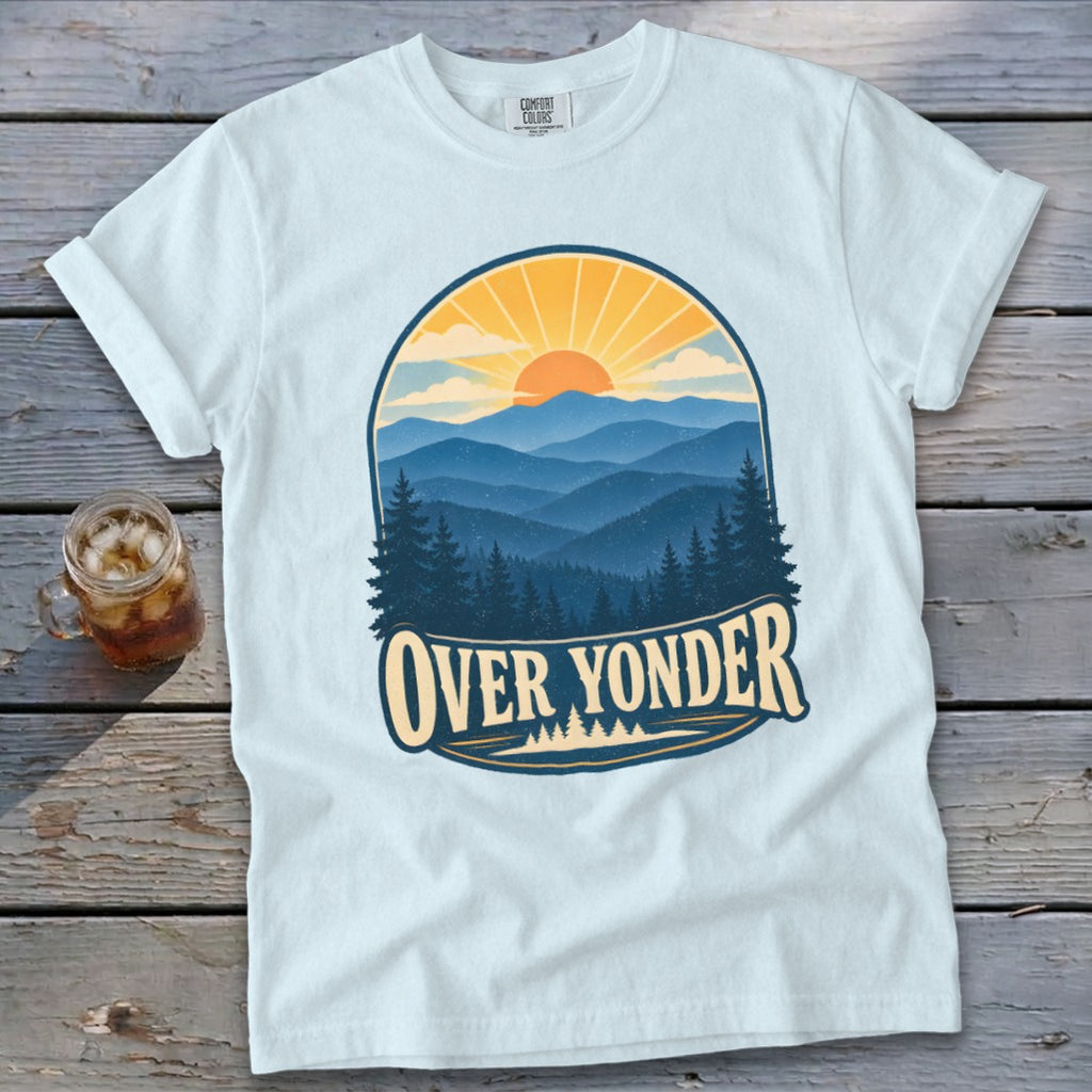 A light blue t-shirt with a retro mountain sunrise graphic and the text Over Yonder.