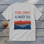 Light gray t-shirt with red, white, and blue text reading Stars, Stripes & Sweet Tea above abstract mountain layers.