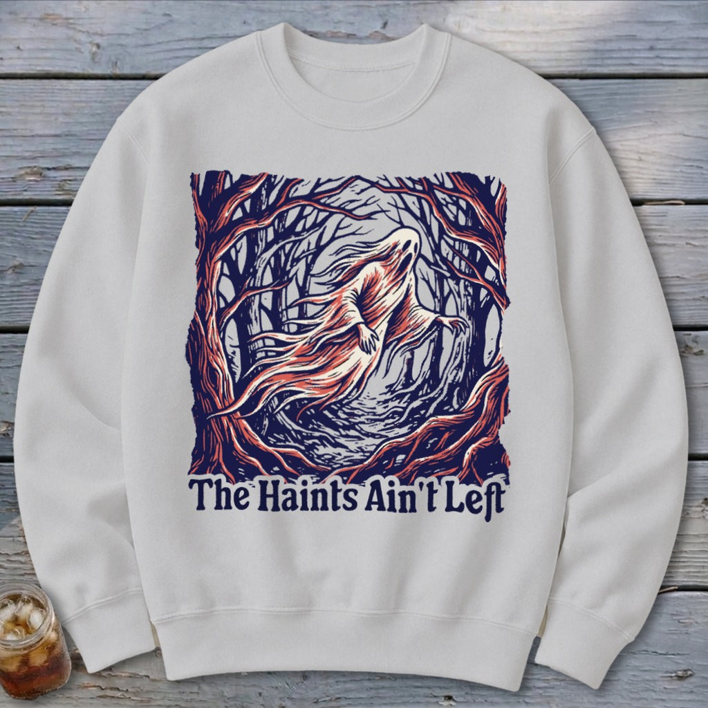 White sweatshirt with a ghost in a forest graphic and text "The Haints Ain't Left".