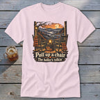 Light pink t-shirt with rocking chairs on a porch, saying "Pull up a chair. The holler's talkin'."