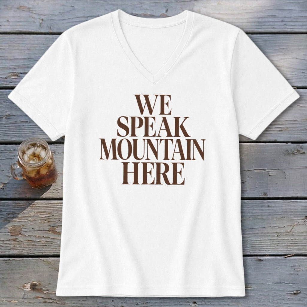 White v-neck t-shirt with brown text "WE SPEAK MOUNTAIN HERE".