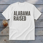 White t-shirt with "ALABAMA RAISED" printed in bold dark gray letters.